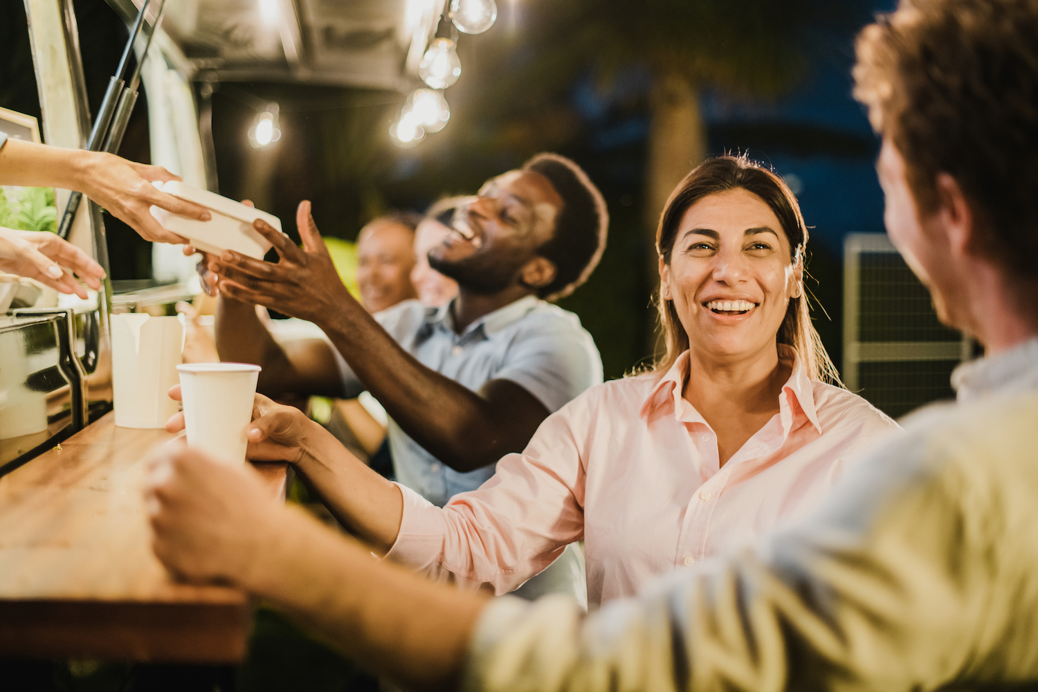 Hispanic woman speaking with friend outside food truck